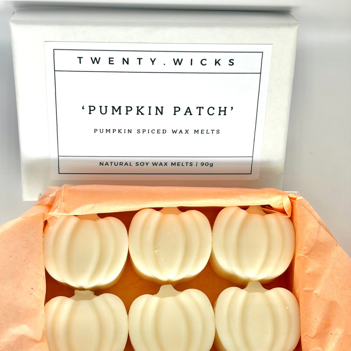 Twenty Wicks 'Pumpkin Patch' pumpkin-shaped wax melts with six white melts visible inside, lined with peach tissue paper